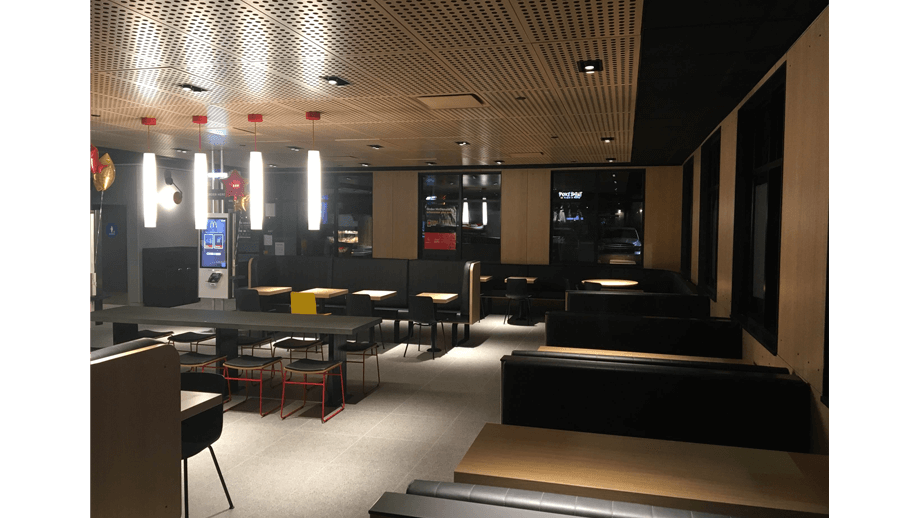 Indoor image of McDonalds showing dining area booths, chairs, tables, and stools.