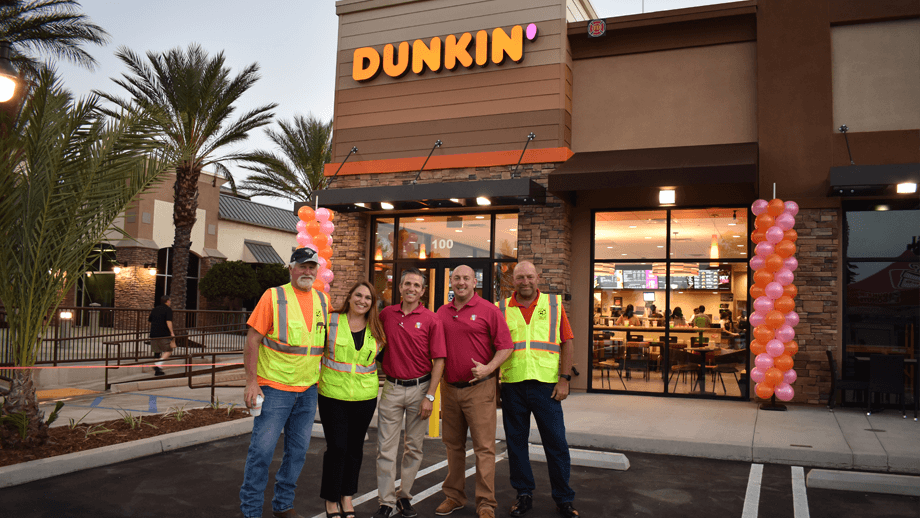 Outdoor image of Dunkin Donuts' main entrance with West Coast Construction team in the foreground.