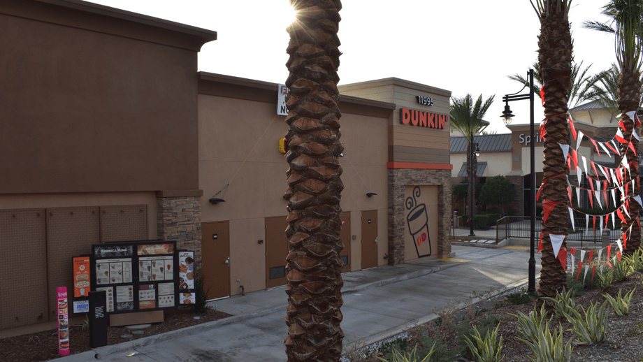 Outdoor image of the back of Dunkin Donuts showing drive through menu.