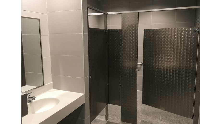 Indoor image of McDonalds showing bathroom stall and mirror.