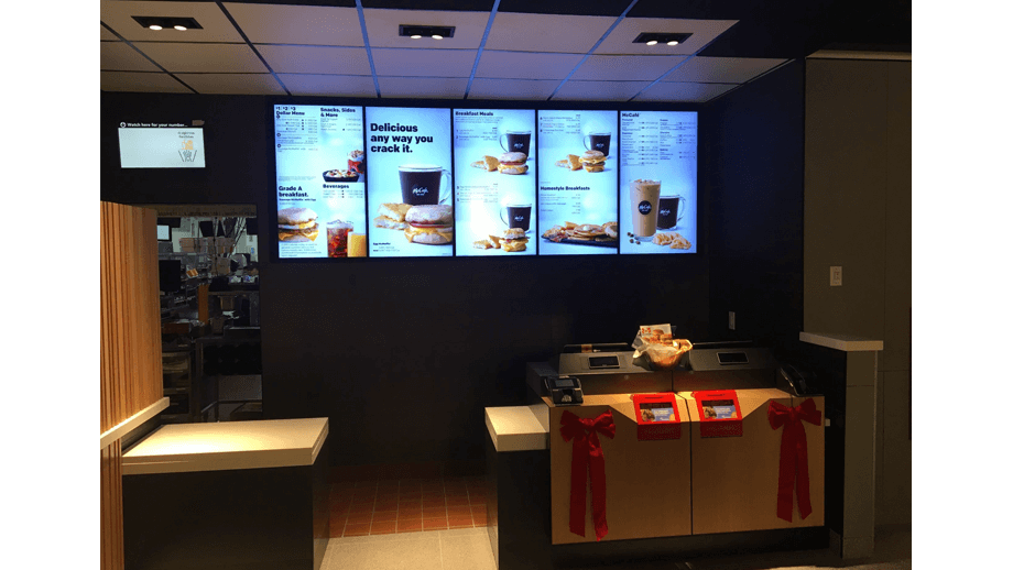 Indoor image of McDonalds showing cashier area and menu screens.