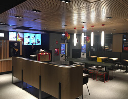 Indoor image of McDonalds showing fabric booths and tall ceiling lamps.